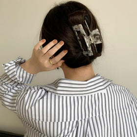 Textention clip next to hand showing scale and comfortable 4.1-inch size