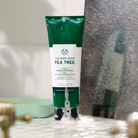 The Body Shop tube next to a coin for scale showing compact travel-friendly 4.2 oz size