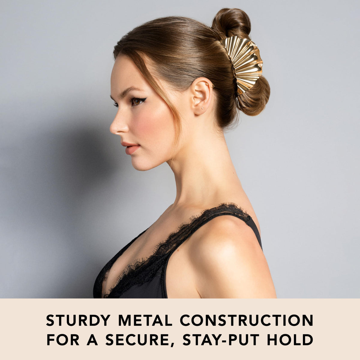 The Hair Edit clip held in hand to show scale and weighted, jewelry-like feel