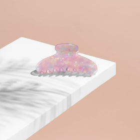 The Hair Edit Unicorn Clip beside a hand to show large size and comfortable handling