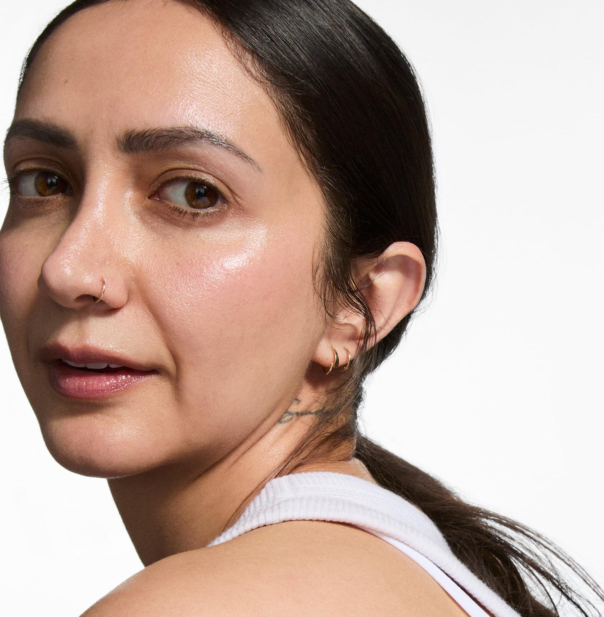 The INKEY List serum being applied to cheeks to demonstrate layering with moisturiser