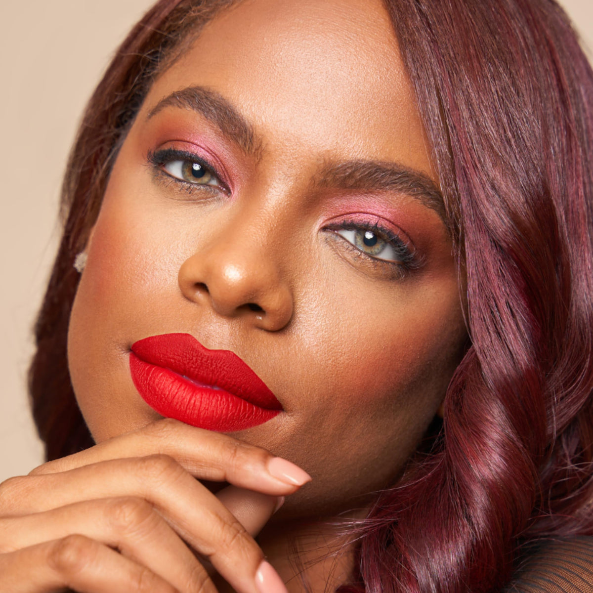 The Lip Bar Hot Mama held in hand illustrates compact size and travel-friendly benefit