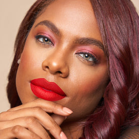 The Lip Bar Hot Mama held in hand illustrates compact size and travel-friendly benefit