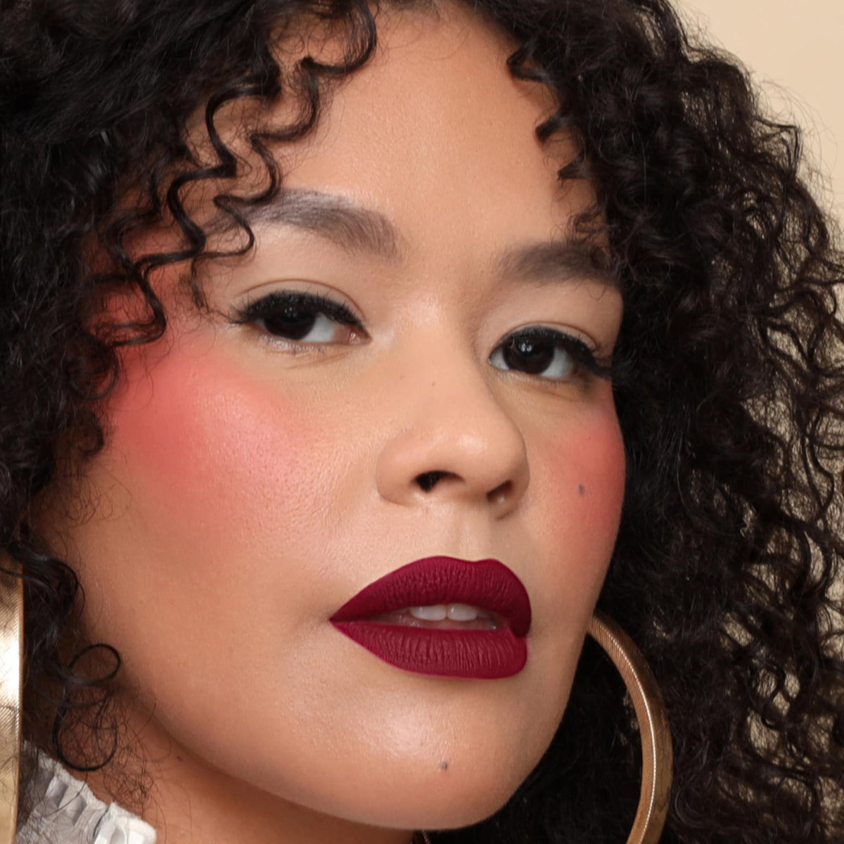 The Lip Bar Muse inside a purse with makeup items, versatile for day-to-night looks