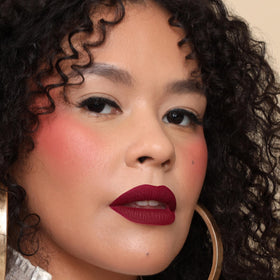 The Lip Bar Muse swatch on skin, deep berry color payoff clearly visible