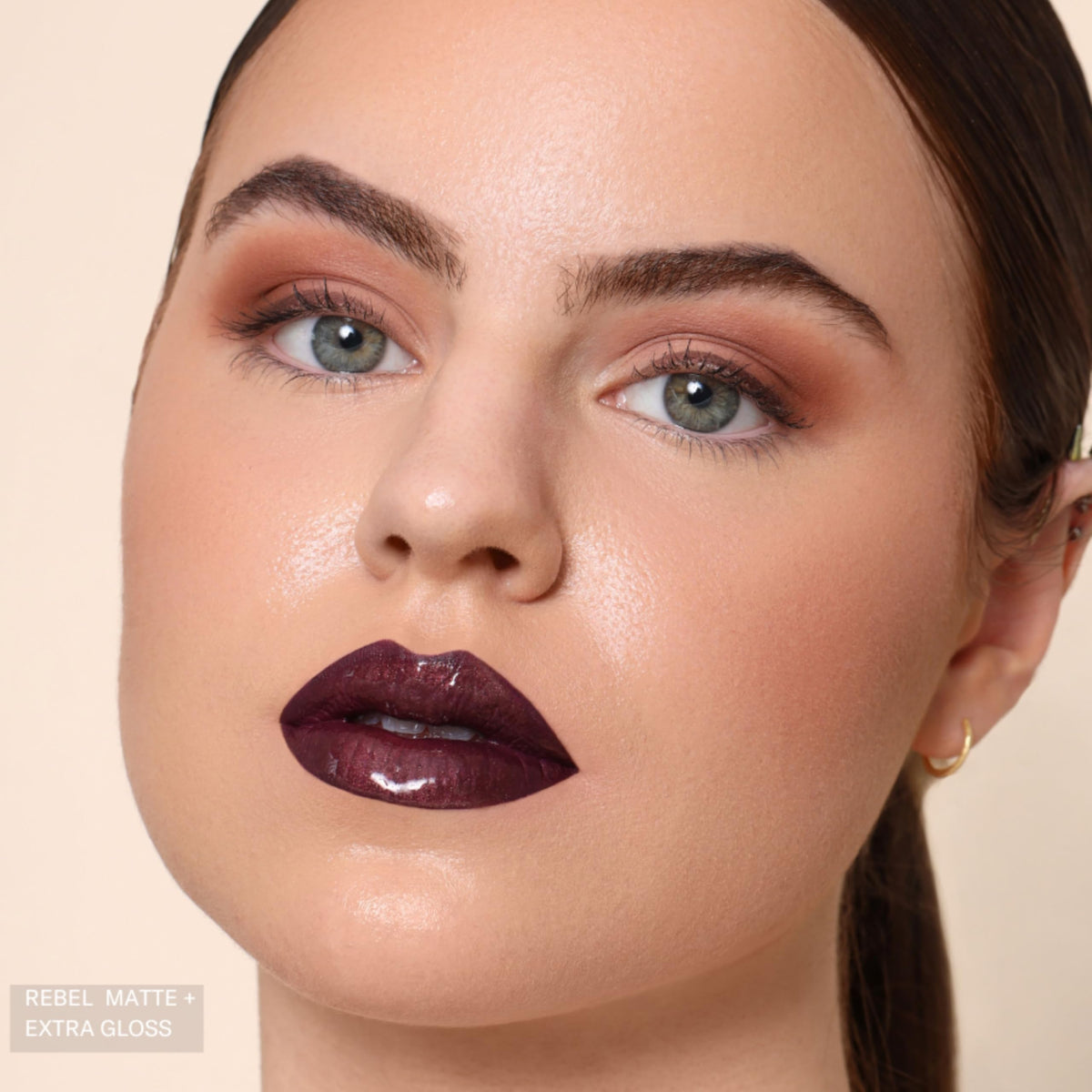 The Lip Bar Rebel held in hand for size comparison showing travel-friendly .24 fl oz
