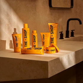 The Shop Uninterrupted bottle beside grooming kit showing barbershop roots and routine benefit