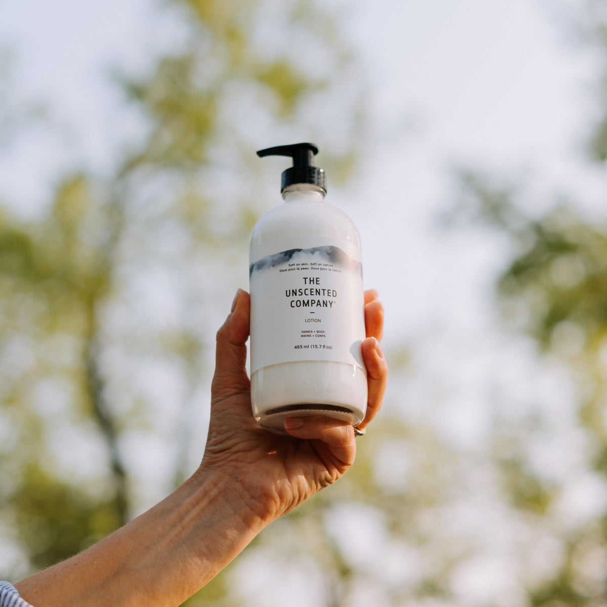 The Unscented Company bottle next to a hand to show the large 16.91 fl oz capacity