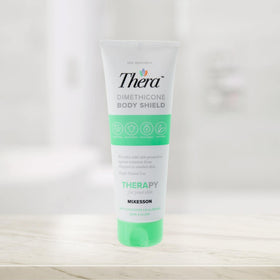 Thera next to a coin for size comparison and travel-friendly 4 oz convenience