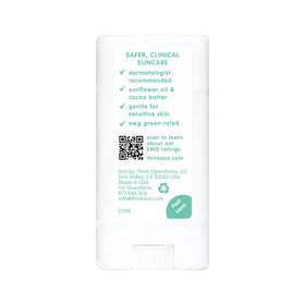 Thinksport stick on beach towel near toys—reef-safe sunscreen for seaside play