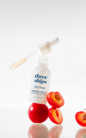 Three Ships 30 mL bottle next to coin showing compact travel-friendly size benefit