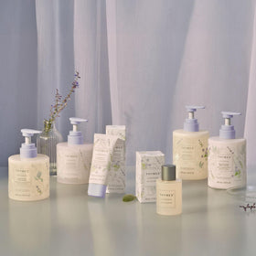 Thymes bottle next to common items to show 9.4 fl oz size and travel practicality