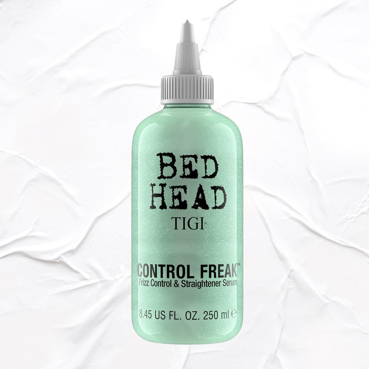 TIGI Bed Head size comparison in hand illustrating 8.45 fl oz capacity and travel visibility