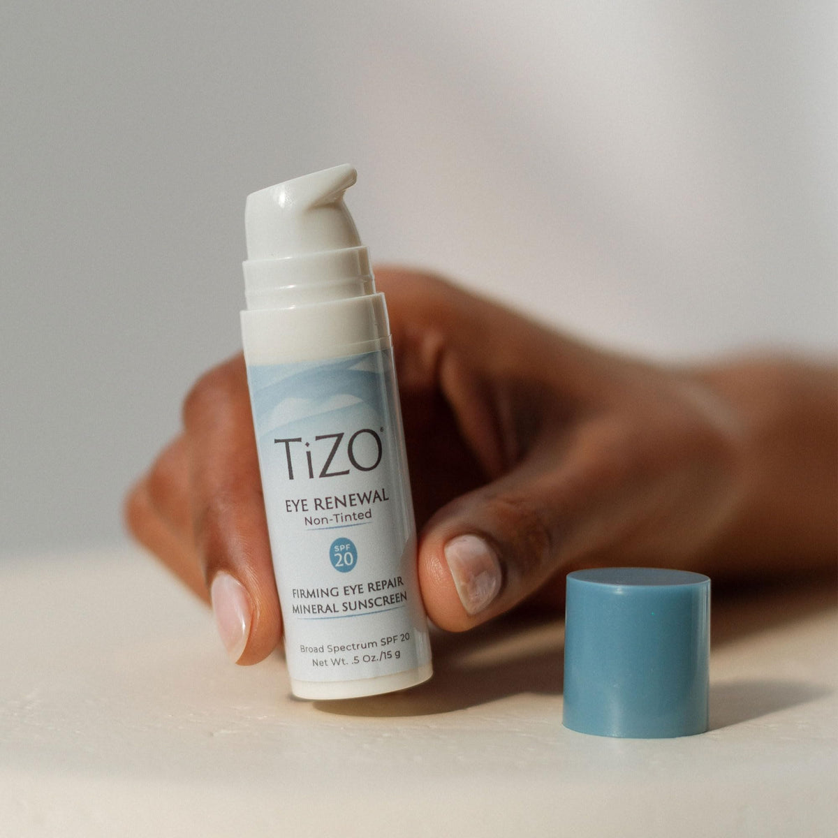 TIZO next to coin to show 0.5 oz size and travel-friendly convenience