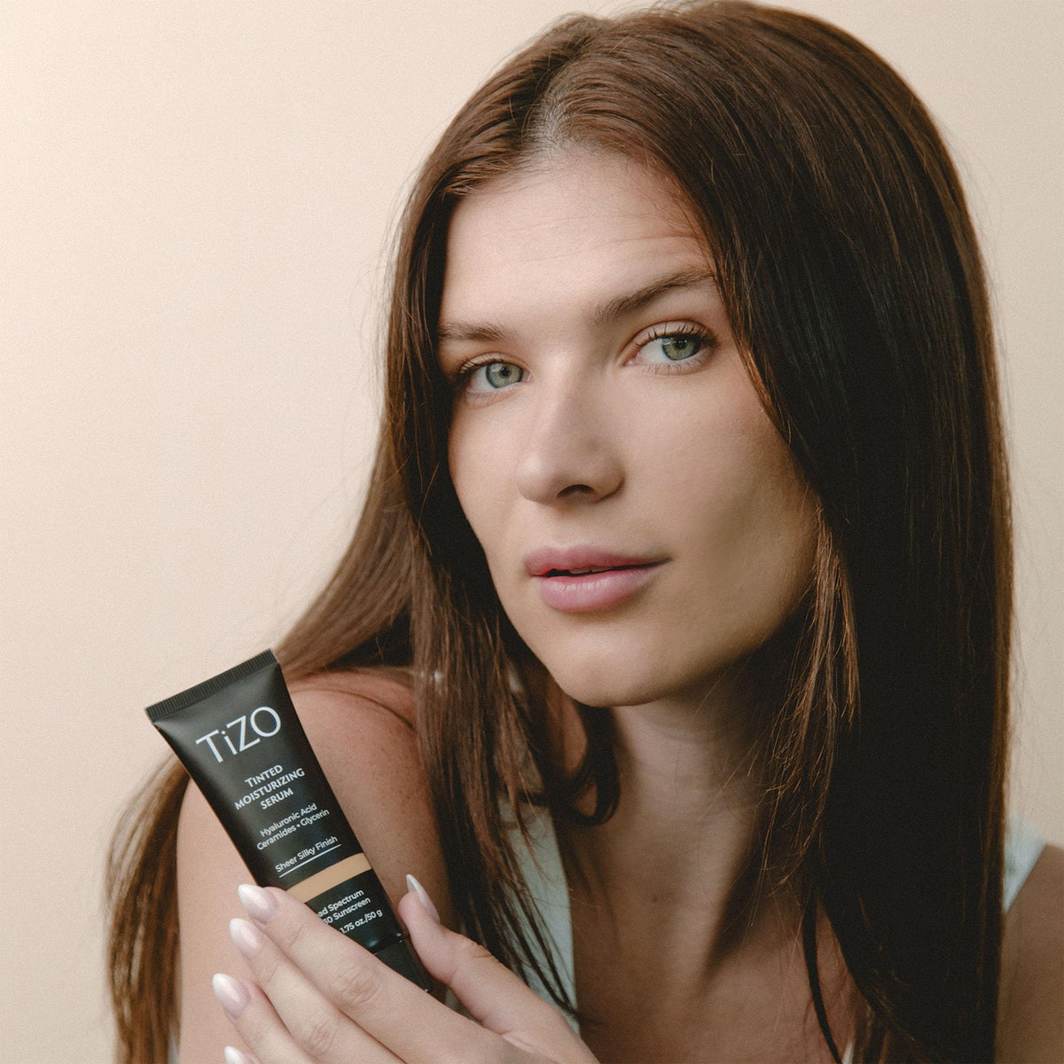 TIZO applying tinted moisturizing serum on face delivering even coverage benefit