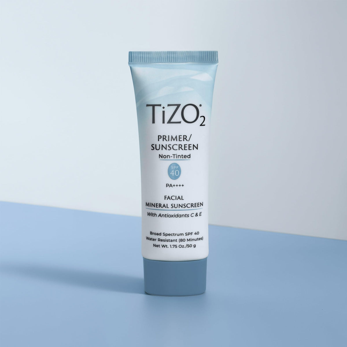 TIZO tube next to hand for scale highlighting convenient 1.75 oz travel-friendly size