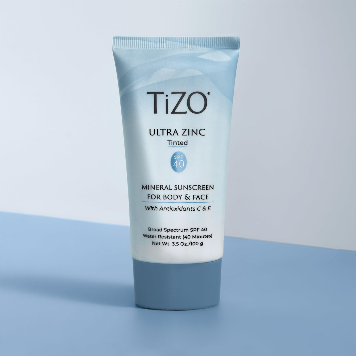 TIZO 3.5 oz tube next to coin for size and portability benefit