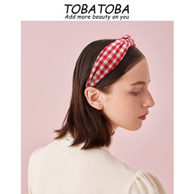 TOBATOBA headband held in hand for scale, shows compact everyday size