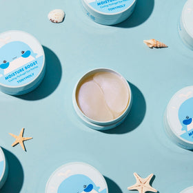 TONYMOLY patches on bathroom vanity with towel, promotes daily self-care benefit