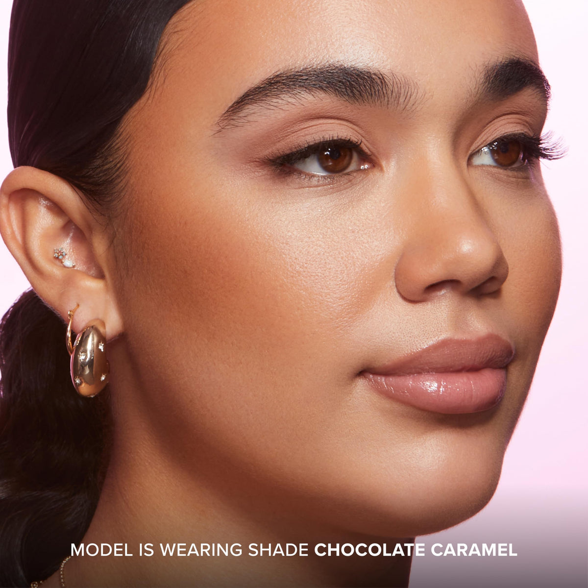 Too Faced stick held in hand to show compact size and easy portability