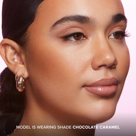 Too Faced stick held in hand to show compact size and easy portability
