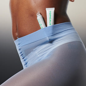 Topicals held in hand for scale showing portable 0.5 fl oz convenience benefit