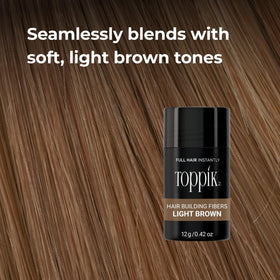 Toppik bottle in hand to show the 27.5g size for convenient everyday carry
