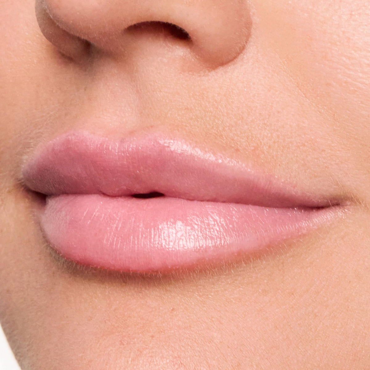 Trish McEvoy Easy Lip Color Dolled Up next to coin showing compact pocket size