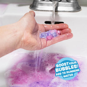Child smiling in bathtub enjoying Tub Works Lil' Bursts for playful, sensory bath time