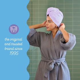 Turbie Twist towel next to hand for scale illustrating generous size for long hair