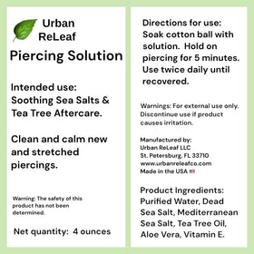 Urban ReLeaf aloe leaf and tea tree sprig beside bottle, showing soothing botanicals