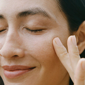 Applying Ursa Major eye cream with ring finger for gentle, precise benefit