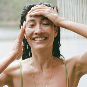 Person applying Ursa Major conditioner in shower for easier detangling