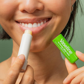 Vaseline applying Aloe Fresh lip balm to lips for instant moisturizing relief