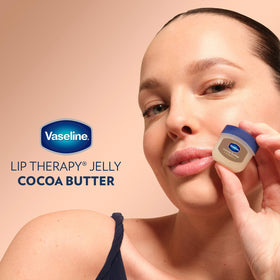 Applying Vaseline cocoa butter onto lips for instant softening and protection