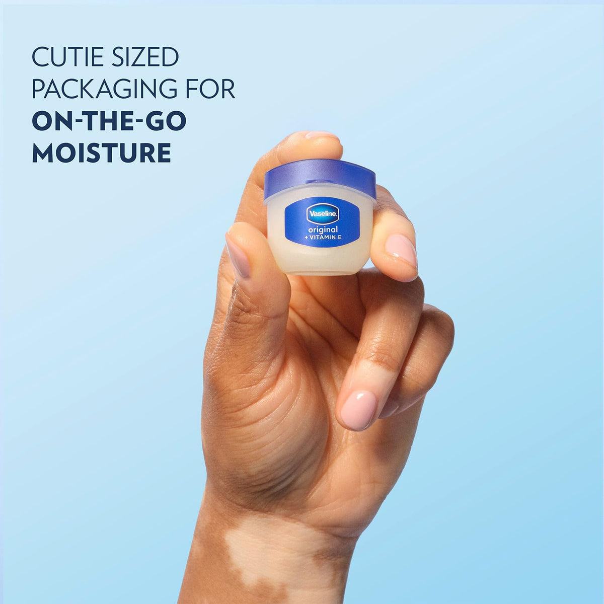 Hand holding Vaseline mini jar to show compact scale and easy portability