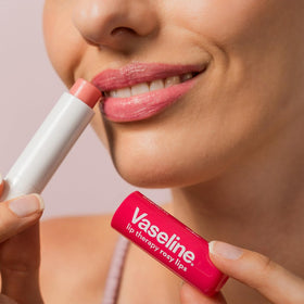 person applying Vaseline balm outdoors illustrating weather protection and quick hydration
