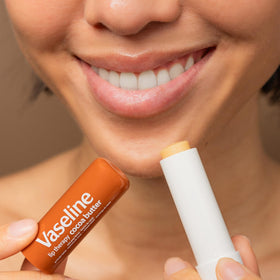Vaseline stick on a nightstand beside water illustrating nightly moisturizing habit