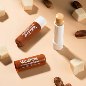 Vaseline stick next to coin to show compact travel-friendly size