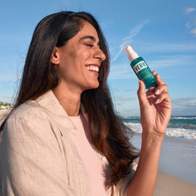 VERB 2 oz bottle next to hand for scale, demonstrating travel-friendly compact size