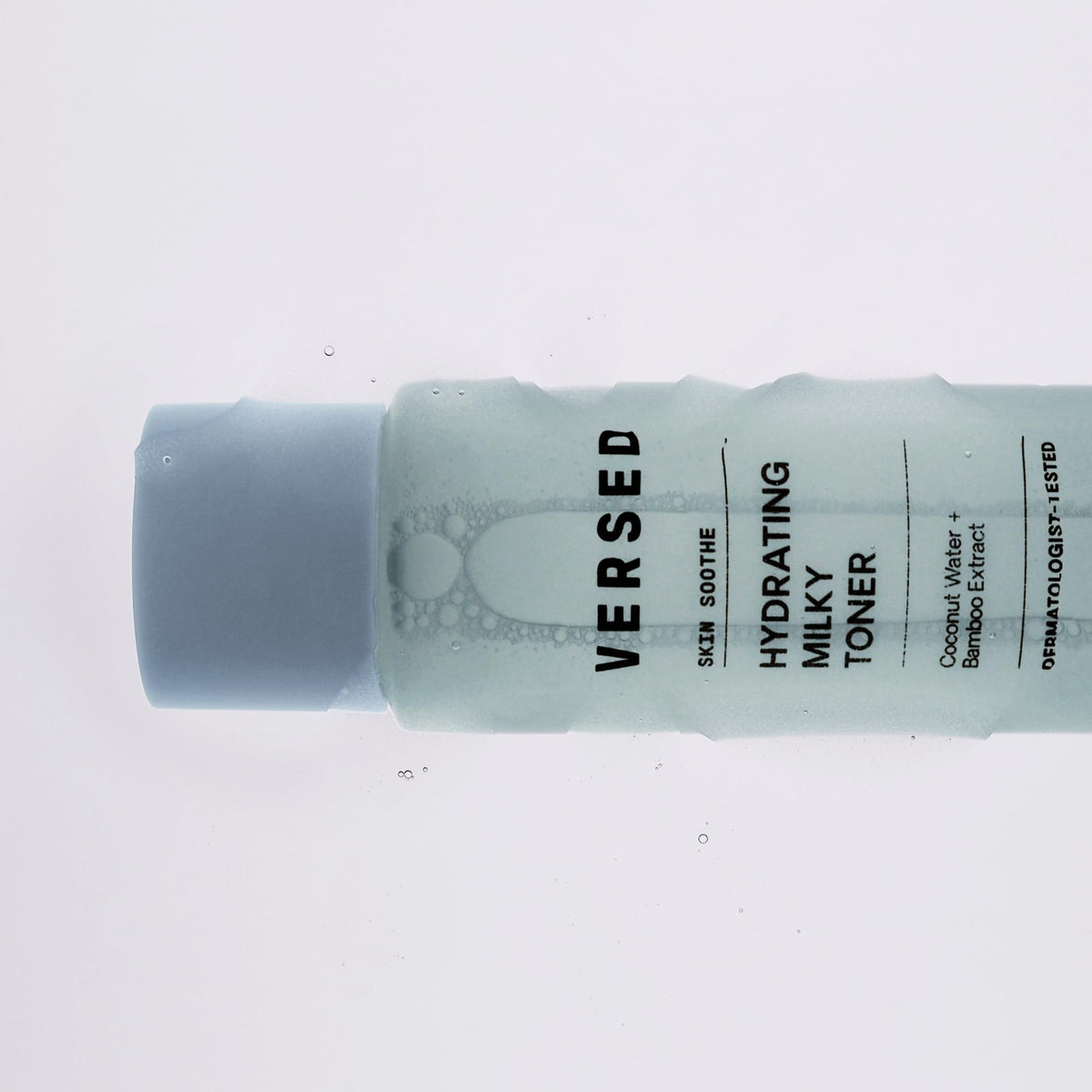 Versed bottle next to coin showing 4 fl oz size and travel-friendly benefit