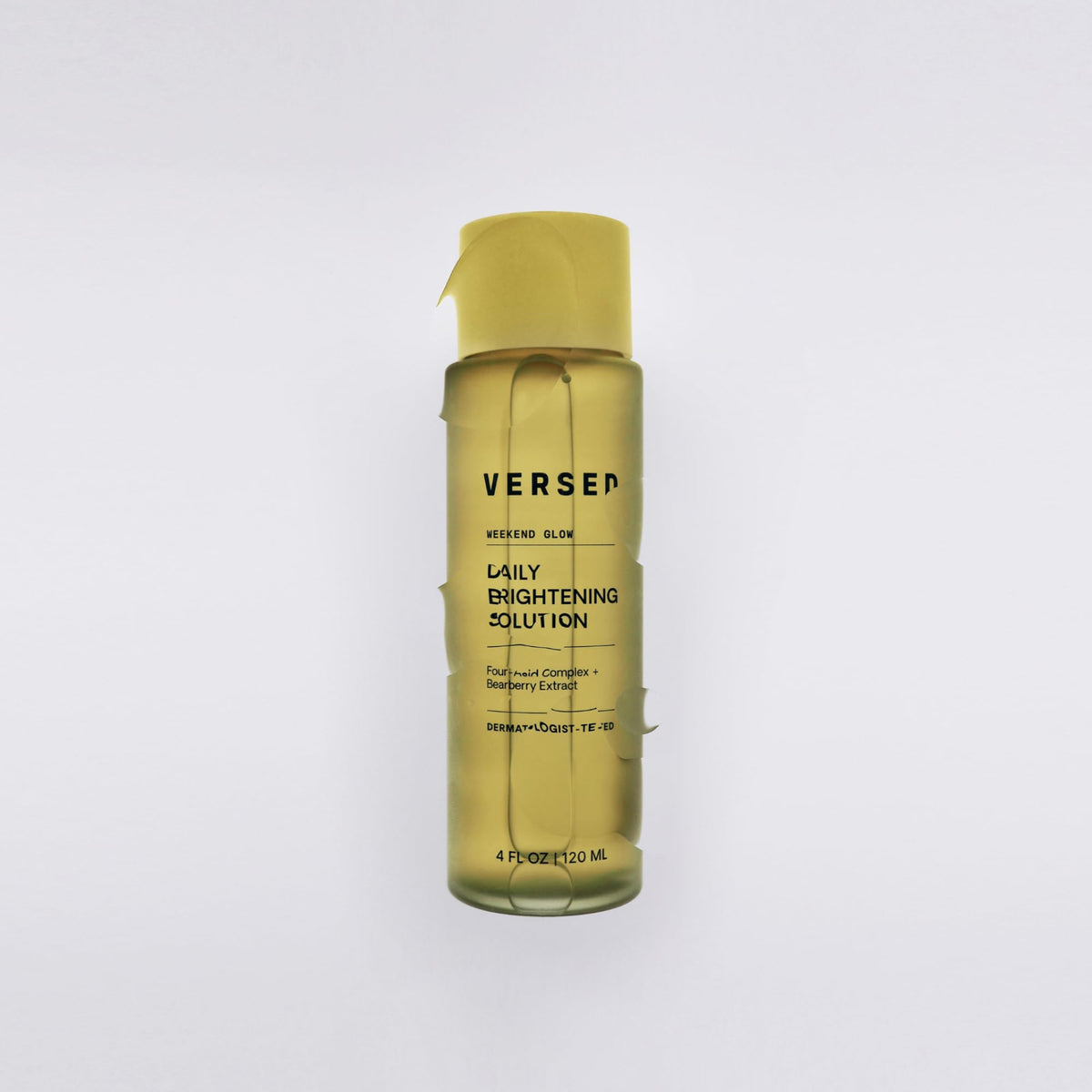 Versed Weekend Glow in hand scale comparing 4 fl oz bottle for travel-friendly size