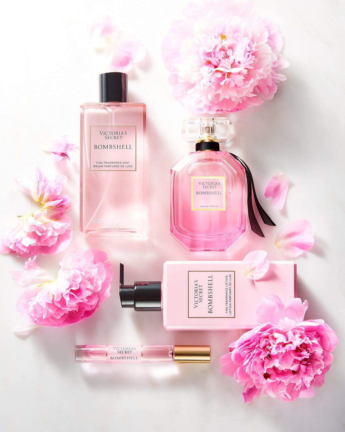 Victoria's Secret bottle in hand for size comparison, conveys 8.4 oz travel-friendly benefit