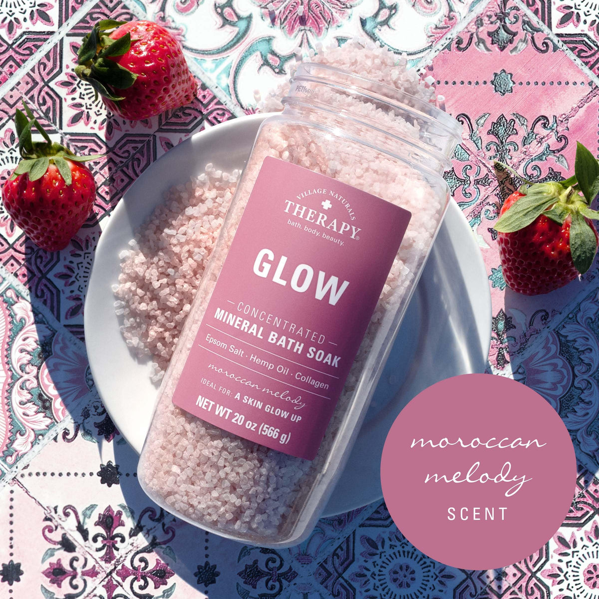 Village Naturals Therapy jar beside bathtub and candles demonstrating relaxing ambiance benefit