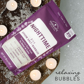Village Naturals Therapy bath setup with candle showing relaxing routine benefit