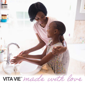 VITA VIE bottle next to a hand to show 12 fl oz size and portability