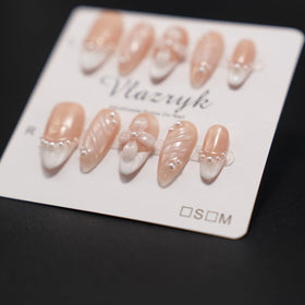 Vlazryk hand applying a press-on nail, showing quick five-minute application benefit