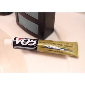 VO5 bottle on bathroom shelf with travel items for on-the-go use