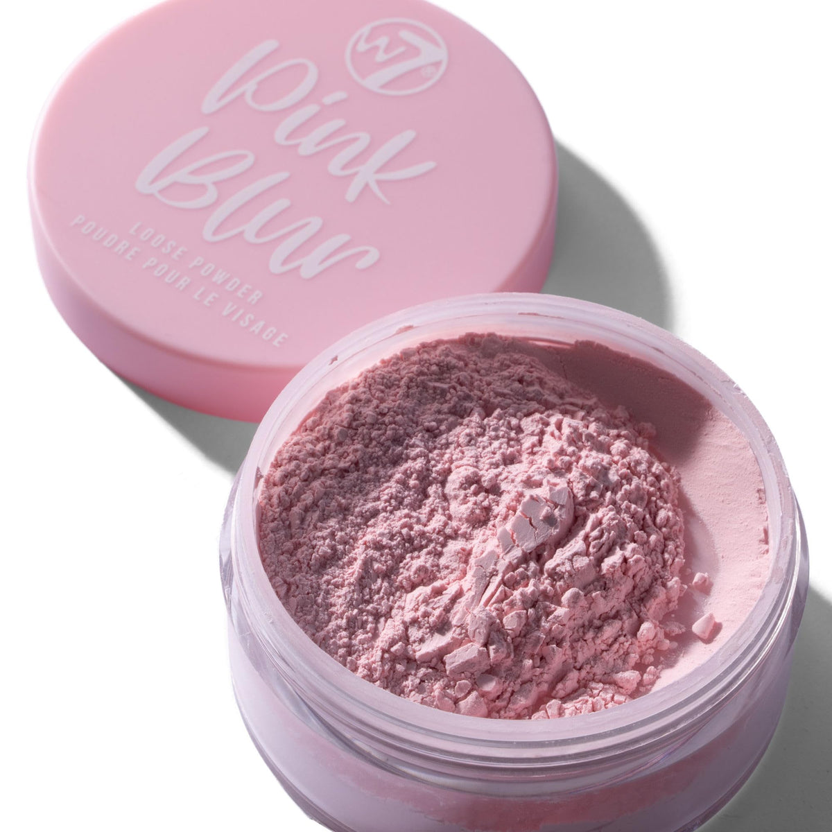 W7 powder jars in hand showing size and portable travel-friendly benefit
