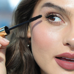 Wander Beauty tube next to coin showing compact travel-friendly size
